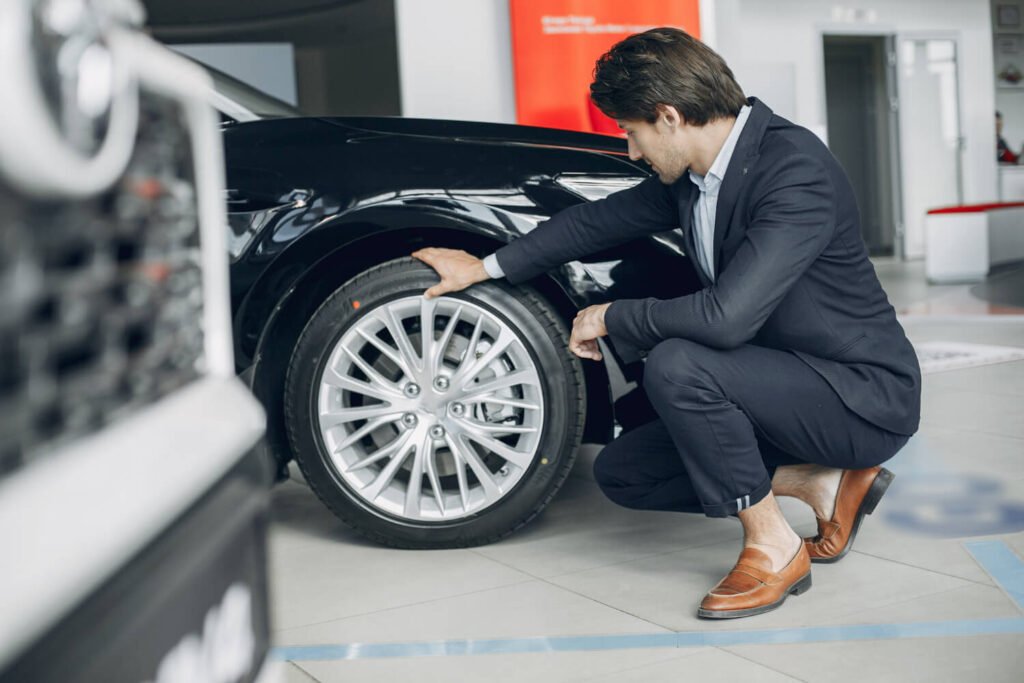 Technician inspecting a wheel and brake area before service at Smart City Tires Miami